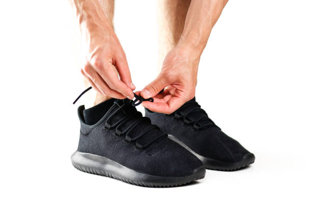 a man tying his shoelaces on black sports shoes. for sports. isolated on white background - 5548 imagens e fotografias de stock