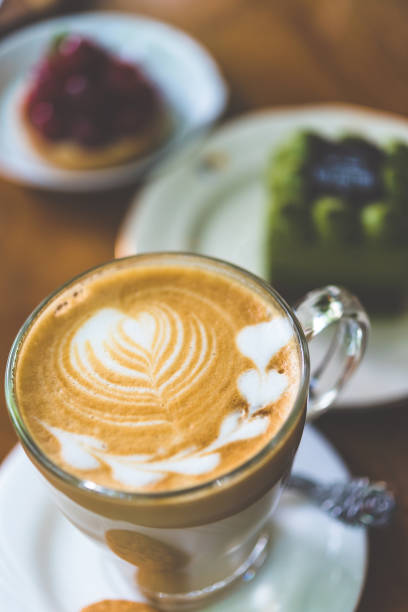 istock Latte art coffee on the table with appetizers at cafe 973676160
