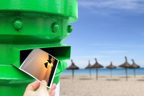 Postbox with a hand throwing a postcard on the beach (monted images elong to the photograph)