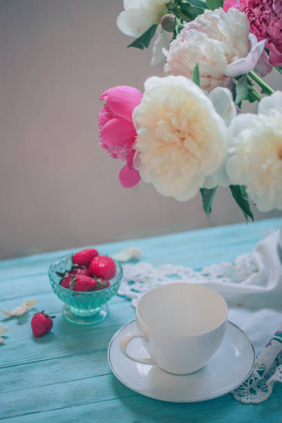 istock White Cup and strawberries and a pitcher of peonies 973682592