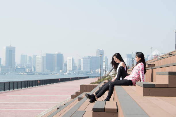 istock Women sitting on the seaside bench and talking. 973682636