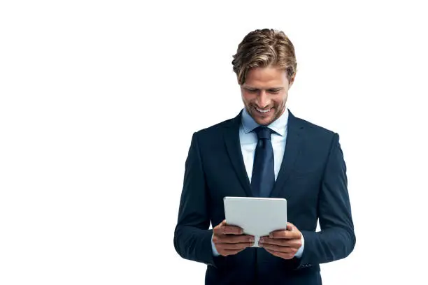 Studio shot of a handsome young businessman using a digital tablet isolated on white