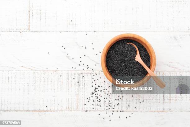 Black Sesame Seeds In A Bamboo Bowl On White Wooden Background Top View Stock Photo - Download Image Now