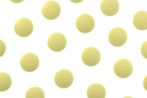 istock Yellow Isolated Pills Pattern Texture. Medical Tablets Background. Macro Closeup. 973707802