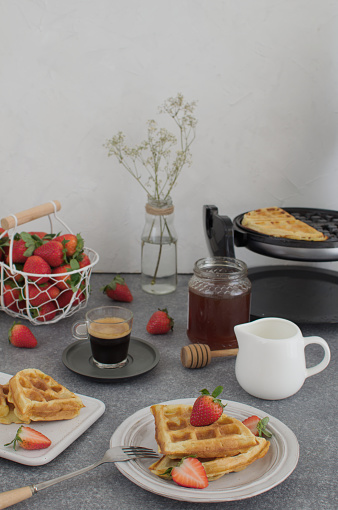 Mesa de desayuno con waffles caseros frescos, miel, café y fresas frescas Lingua parole chiave: En photo