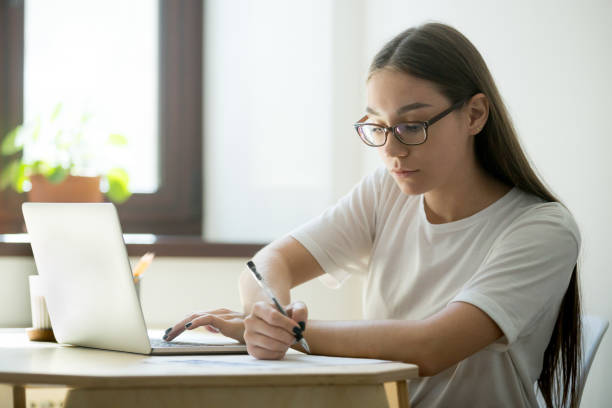 istock Serious student working at laptop preparing for exams 973708774