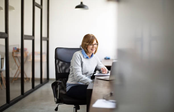 istock Senior woman working at her office desk 973715250