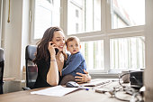 Single mother with son working in office