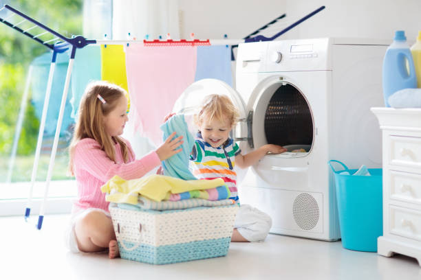 kinder in der waschküche mit waschmaschine - water softener stock-fotos und bilder