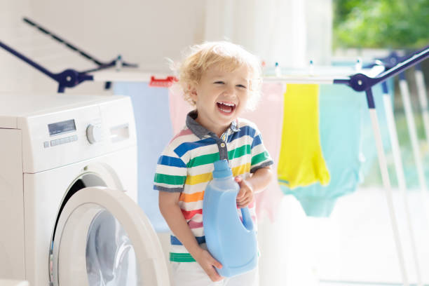 istock Child in laundry room with washing machine 973726142