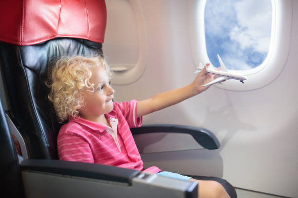 istock Child flying in airplane. Flight with kids. 973726432