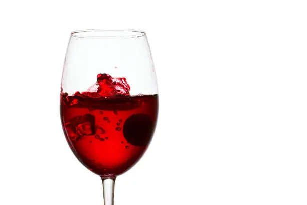 Photo of spectacular small splash of red wine in a glass