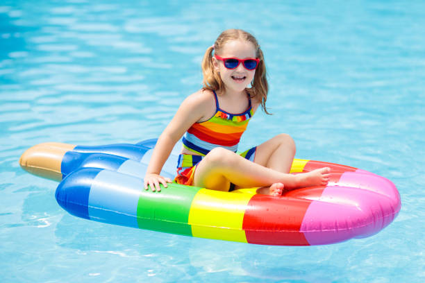 istock Child on inflatable float in swimming pool. 973735946