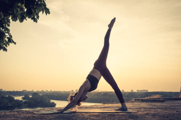 istock Woman practising yoga outdoors. Summer sunset 973745882
