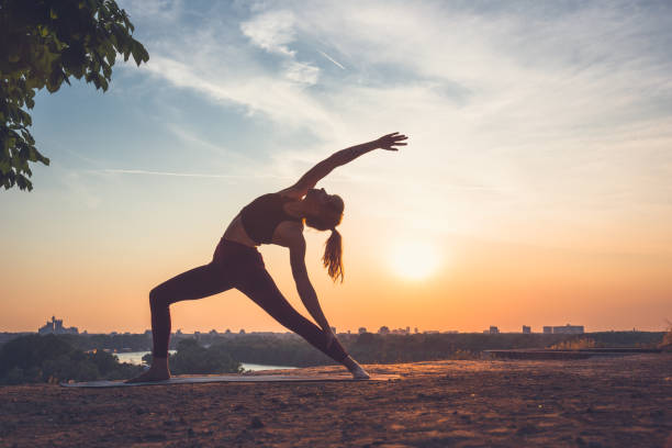 istock Woman practising yoga outdoors. Summer sunset 973745930