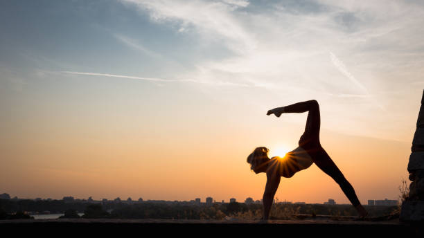istock Woman practising yoga outdoors. Summer sunset 973745950