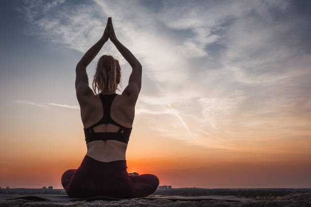 istock Woman practising yoga outdoors. Summer sunset 973746034