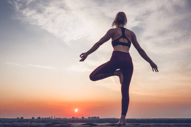 istock Woman practising yoga outdoors. Summer sunset 973746048