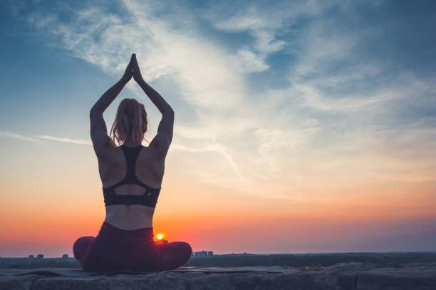 istock Woman practising yoga outdoors. Summer sunset 973746050