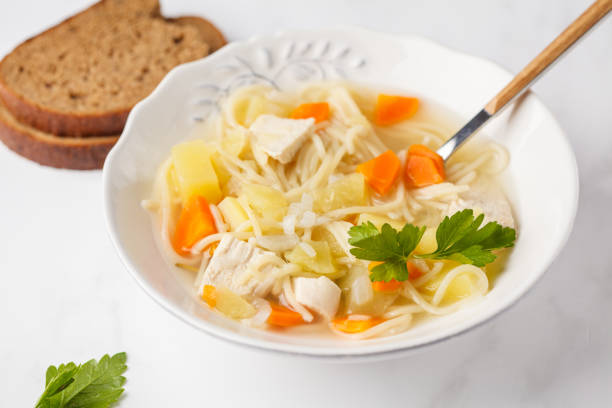 istock Chicken soup with noodles and vegetables in a white plate. 973746148