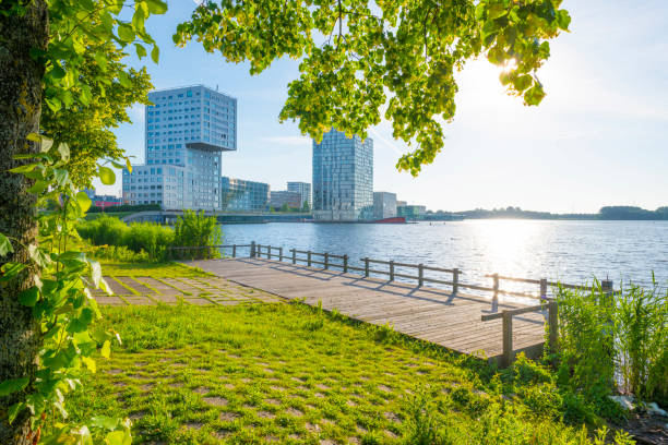 Skyline of a city along the shore of a lake at sunrise in spring Skyline of a city along the shore of a lake at sunrise in spring almere photos stock pictures, royalty-free photos & images