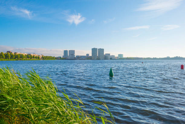 skyline de una ciudad a lo largo de la orilla de un lago al amanecer en primavera - almere fotografías e imágenes de stock