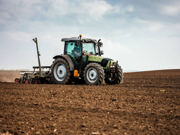 istock Farmer seeding, sowing crops at field. 973753592