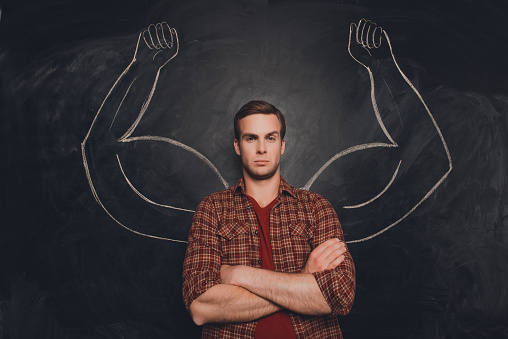 Young handsome man in  shirt with drawn powerful hands