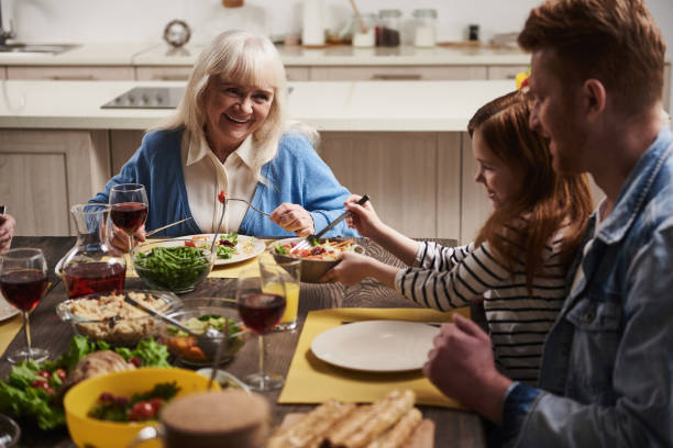 istock Smiling elderly woman communicating at dinner with family 973757500