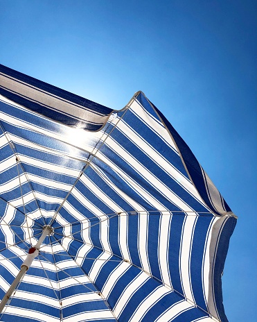 Blue and white striped beach umberella in blue sky, Antalya,Turkey