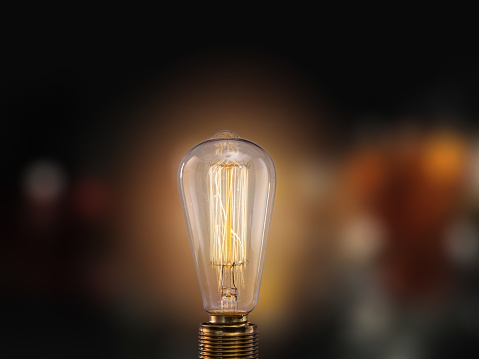 Vintage light bulb on dark background with empty space for text.