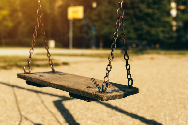 istock Old abandoned swing on children's playground 973767646