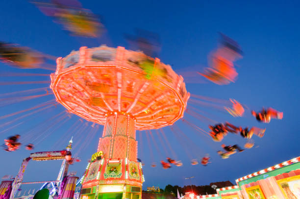 carousel with flying people at oktoberfest in munich, germany - amusement park oktoberfest munich chain swing ride imagens e fotografias de stock