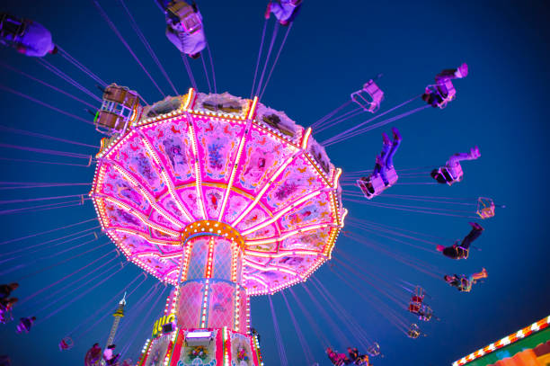 carrossel com pessoas a voar na oktoberfest em munique, alemanha - amusement park oktoberfest munich chain swing ride - fotografias e filmes do acervo