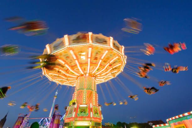 carousel with flying people at oktoberfest in munich, germany - amusement park oktoberfest munich chain swing ride imagens e fotografias de stock