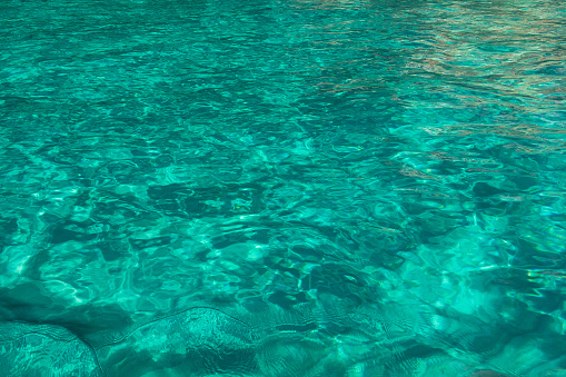 Texture of turquoise ocean water with reflections