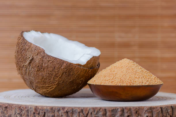 органический кокосовый сахар в миске на коричневом фоне - powdered coconut стоковые фото и изображения