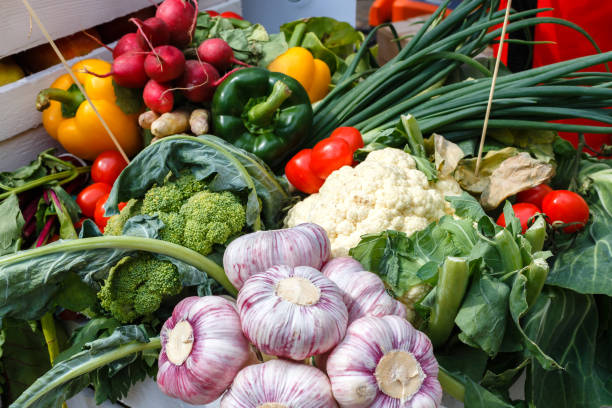 istock Fresh vegetables - garlic, cauliflower, greenery, onion on a picnic table on a summer day 973800894