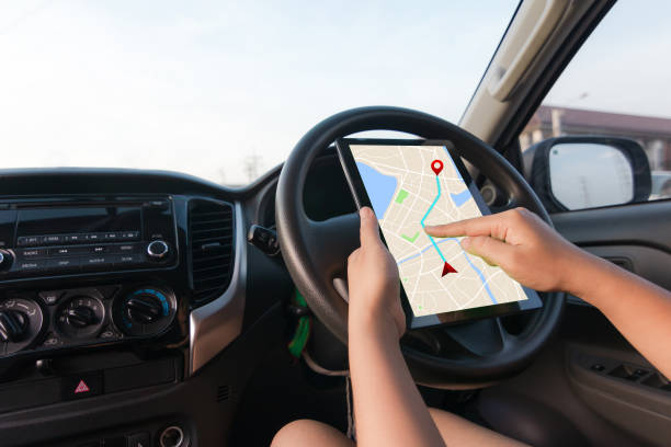 istock Hand of woman using tablet with gps navigator map application in SUV car 973808550