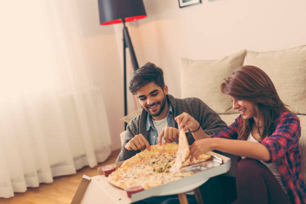 istock Couple eating pizza and having fun 973809426