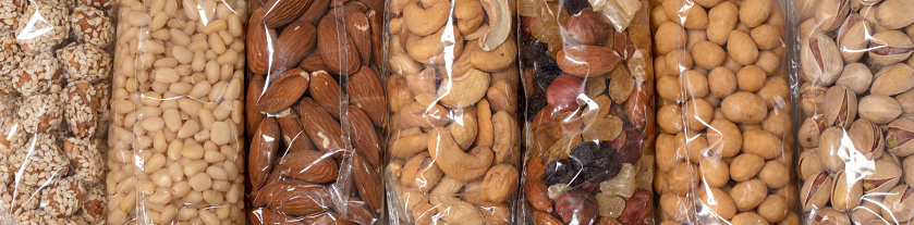 Set of different nuts in transparent plastic packages.