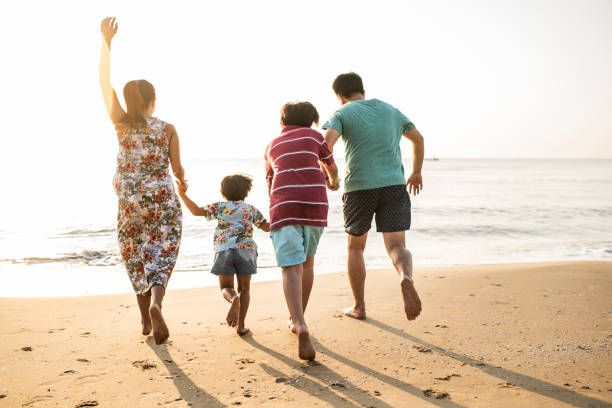 istock Asian family playing at the beach 973826086