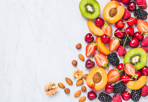 istock Fresh fruits and berries on white marble. 973832282
