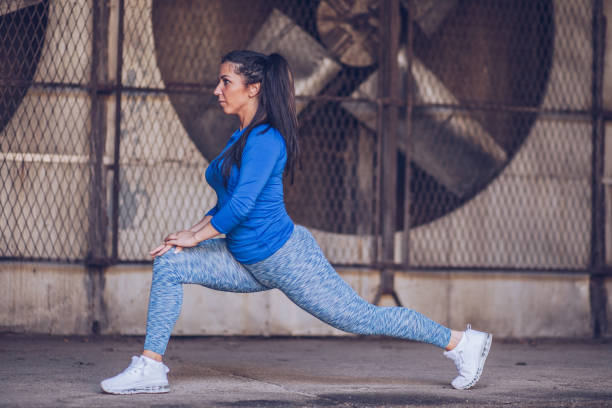 istock Sporty young woman stretching 973833664