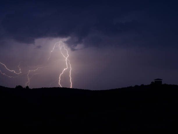 istock Lightning strike over hill in the night. 973849982