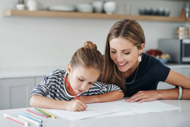 istock Assisting her with homework is what a mother does 973850712