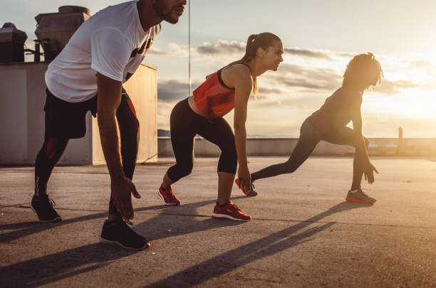 istock Small Group of Athletes Exercising Outdoors 973852010