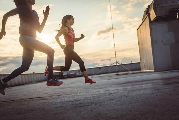 istock Two Female Athletes Exercising, Running Outdoors 973852030