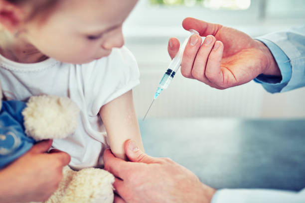 Professional pediatrician vaccinating baby, close up stock photo