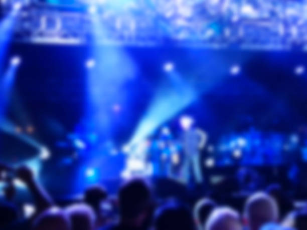 istock Blurred abstract background. Bokeh lighting in concert with audience. 973857928